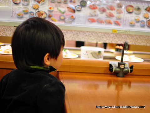 お寿司のレーンを見つめる息子